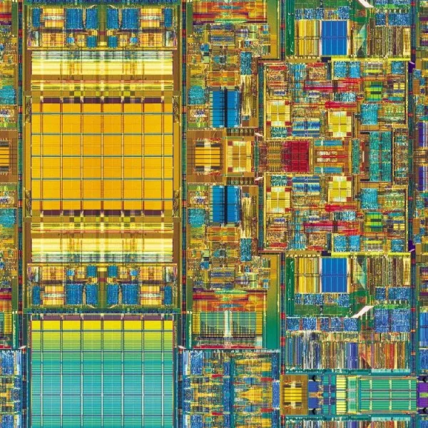 Close-up of a colorful and intricate microchip layout. The design features various geometric shapes in vibrant hues of yellow, blue, red, and green, illustrating the complex architecture and connectivity of electronic circuitry.