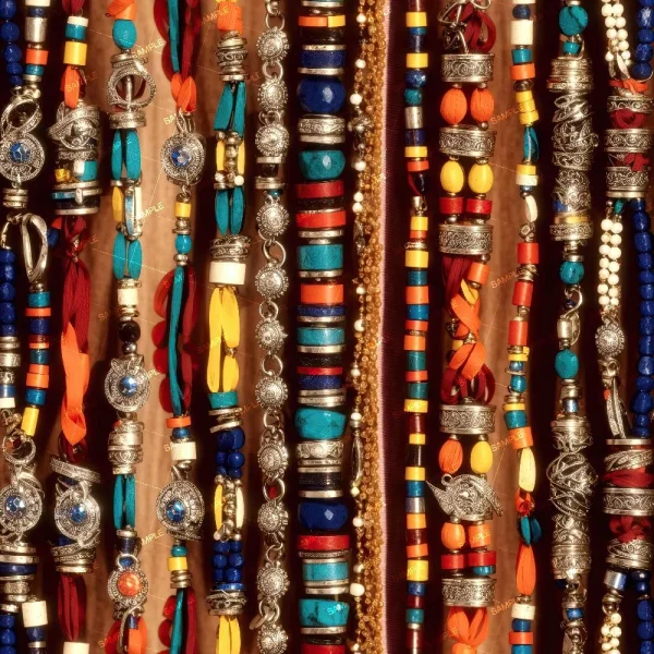 A variety of colorful beaded necklaces arranged vertically. The necklaces feature an assortment of beads in different shapes, sizes, and colors, including blue, red, yellow, and turquoise, along with ornate silver accents.