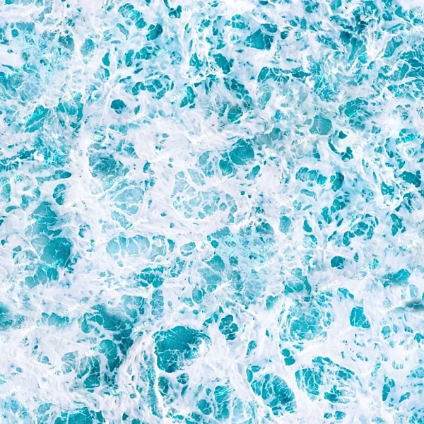 Aerial view of a turbulent ocean surface, showing a mix of blue and white swirling waves. The foam and waves create an intricate pattern on the water.