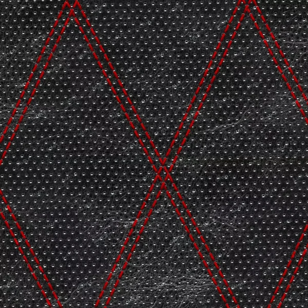 Close-up of perforated black leather with a pebbled texture, featuring a geometric red diamond-shaped stitching pattern.