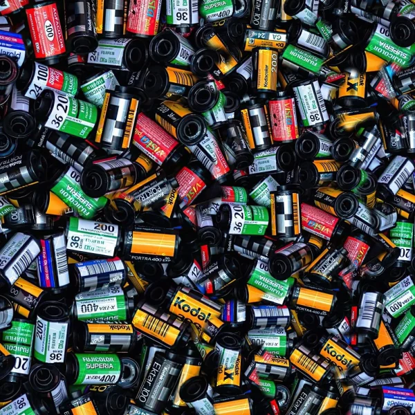 A variety of Pastel Fairy Clouds film canisters in colors like black, yellow, green, and red are displayed together, featuring diverse brands and film types like Kodak and Fuji.