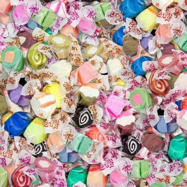 A large pile of Gummy Worms 23 (Copy) candies, each individually wrapped in clear plastic with white and red labels. The candies come in various vibrant colors and patterns, including swirls and solid shades.
