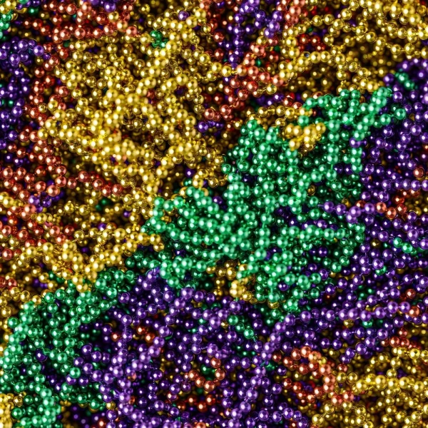 A close-up of Mardi Gras Streamers (Copy) showcases densely packed, tangled metallic beads in green, gold, purple, and red, creating a shiny and colorful texture perfect for festive decorations.