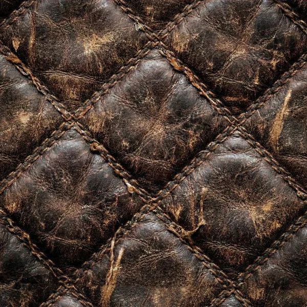 Close-up of Distressed Diamond Stitched Leather 43 (Copy), featuring a quilted diamond pattern, visible stitching, and signs of wear such as scratches and uneven brown coloration across the surface.