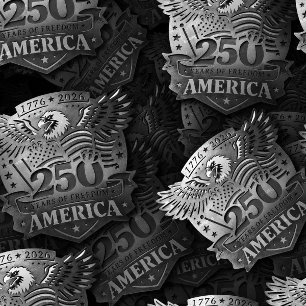 A pile of 250 Years of Freedom 22 metallic badges features an eagle, the number 250, the years 1776–2026, stars, and the word “America.” These badges commemorate 250 years of freedom in the United States.